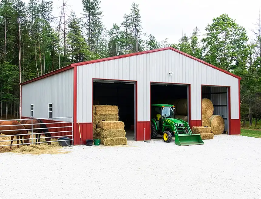 Red metal barn with horses and tractor
