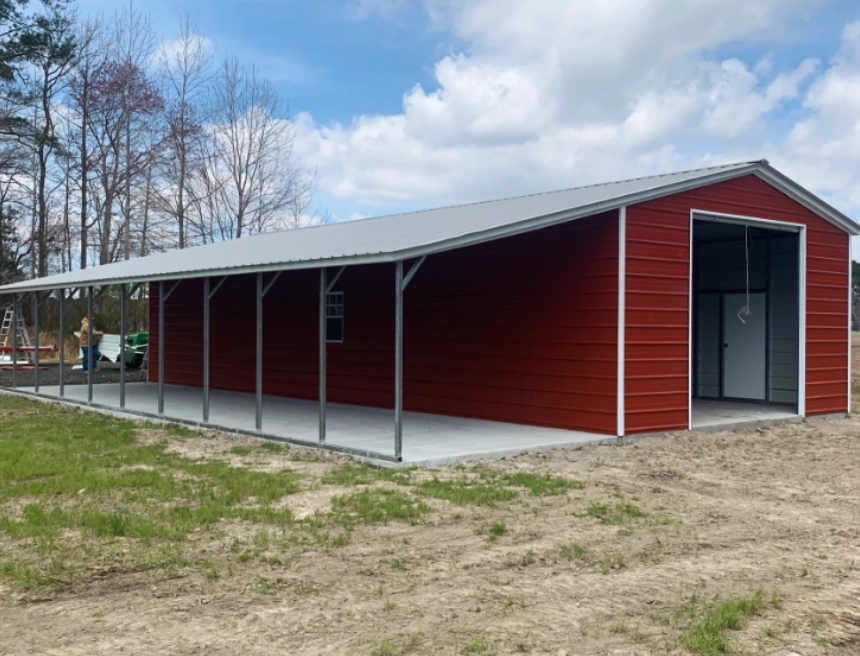 Red metal barn with horses and tractor